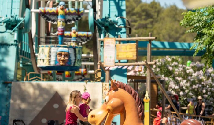 OK CORRAL est un parc d’attractions dans le Sud de la France qui offre des manèges pour toute la famille, comme ce cheval à bascule où une mère et sa fille s'amusent dans une ambiance conviviale. Les animations en plein air et le décor Far West créent une expérience immersive pour les enfants.

OK CORRAL, parc à thème familial, propose une zone aquatique et des attractions pour enfants, idéales pour une journée en famille. La mère et sa fille
