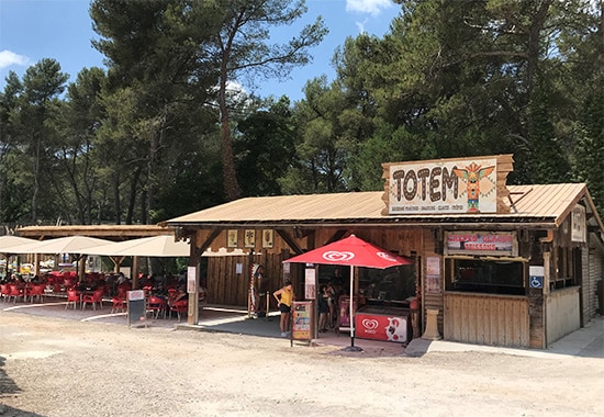 OK CORRAL propose une ambiance conviviale avec le stand de restauration "TOTEM", parfait pour une pause gourmande en famille. Ce parc d’attractions dans le Sud de la France offre un cadre naturel entouré de pins, idéal pour se détendre entre deux manèges pour toute la famille. Les tables en extérieur sont parfaites pour partager un moment festif après avoir profité des attractions pour enfants et des spectacles western.